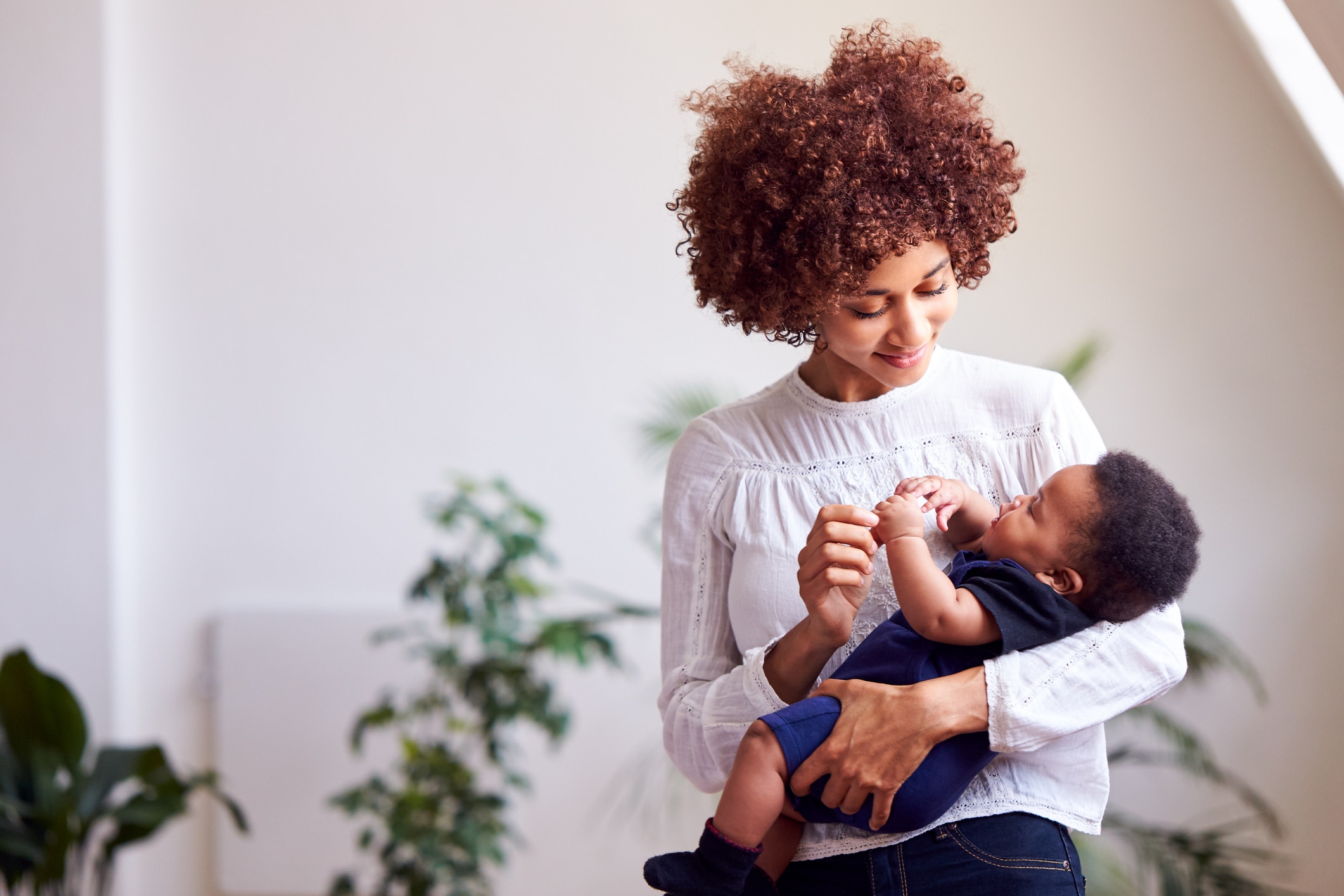 Mother holding baby and considering Mommy Makeover surgery